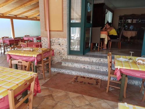 a restaurant with tables and chairs and a woman sitting at a table at Hotel Nautilus in Nicotera Marina