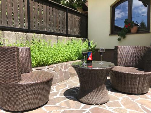 a patio with three chairs and a table with a glass of wine at Bled Home in Bled