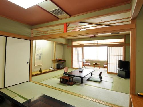 a living room with a table and a dining room at Nisshokan Shinkan Baishokaku in Nagasaki