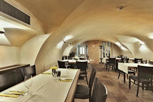 a dining room with white tables and chairs at Wellness Hotel Republika 24 Apartments in Plzeň