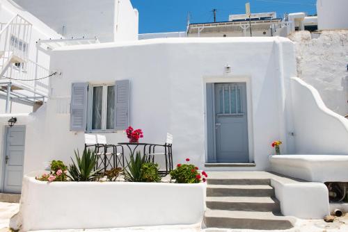 a white house with a blue door and stairs at Chora House in Mikonos