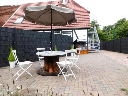 a table and chairs with an umbrella on a patio at Pension Ostseeurlaub in Rostock