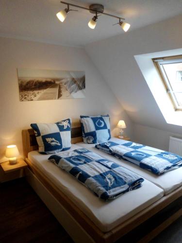 um quarto com 2 camas com almofadas azuis e brancas em Pension Ostseeurlaub em Rostock