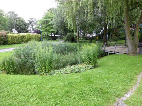 ein Park mit einer Bank und einem Grasfeld in der Unterkunft Pension Ostseeurlaub in Rostock