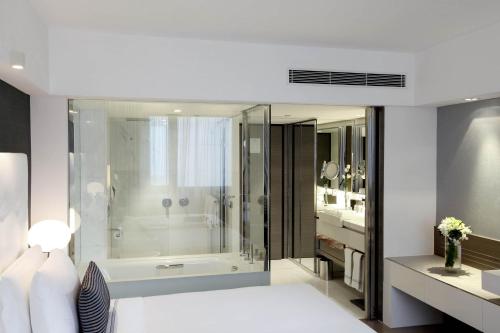 een badkamer met een bad, een douche en een wastafel bij The Mira Hong Kong in Hong Kong