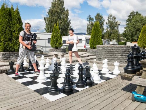 two people playing chess on a giant chessboard at Beverøya Hytteutleie og Camping in Bø