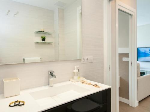 a white bathroom with a sink and a mirror at Beachfront Apartment Siesta 21 San Agustin Playa by VillaGranCanaria in San Agustin