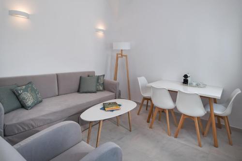 a living room with a couch and a table and chairs at Altemar Suites in Fira