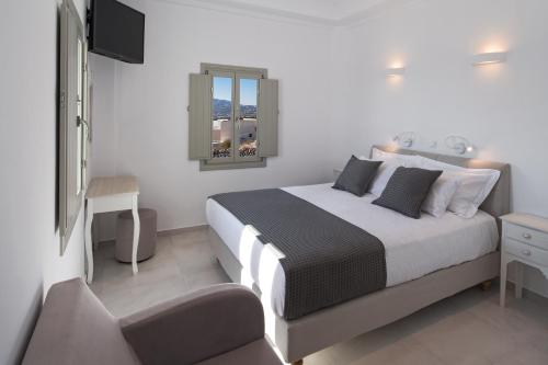 a bedroom with a large bed and a window at Altemar Suites in Fira