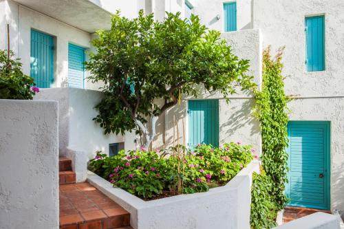 a building with blue doors and flowers in front of it at Villa Iokasti in Hersonissos