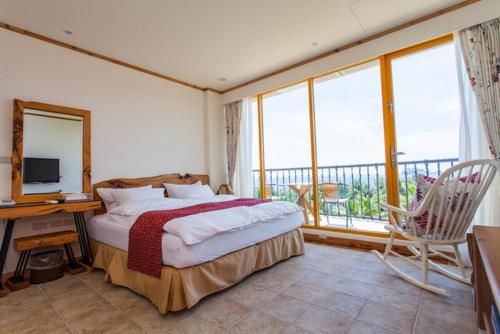 a bedroom with a bed and a desk and a television at Tung Lodge - Taitung Branch in Chenggong