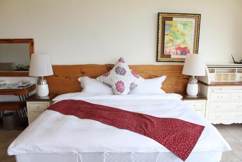 a bedroom with a white bed with a red blanket on it at Tung Lodge - Taitung Branch in Chenggong