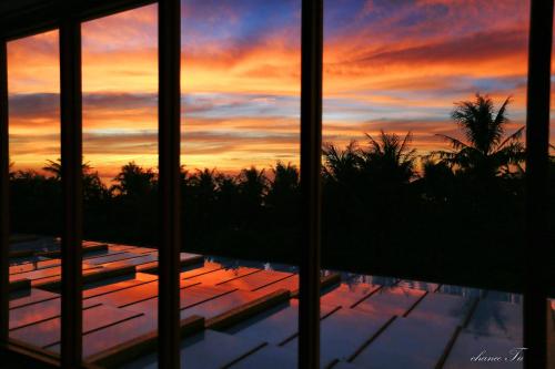 a view of a sunset from a house with a pool at Tung Lodge - Taitung Branch in Chenggong