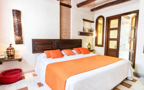 1 dormitorio con 1 cama grande con almohadas de color naranja en Casa de Federico Boutique, en Granada