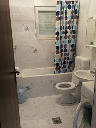 a bathroom with a tub and a toilet and a sink at Apartment Tea in Rab