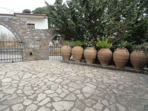 a row of vases lined up next to a fence at Zeus House in Agios Konstantinos