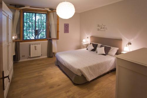 1 dormitorio con cama y ventana grande en La Maison B&B di Brigitte e Simone, en Bentivoglio