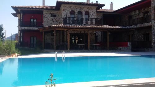 a large swimming pool in front of a house at Monastiri Guesthouse in Kalabaka