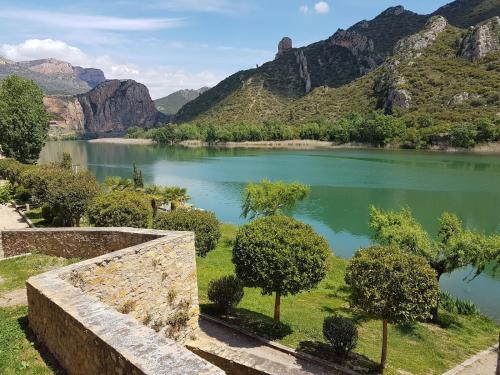 a lake with trees and mountains in the background at Hostal Sant Miquel in Balaguer