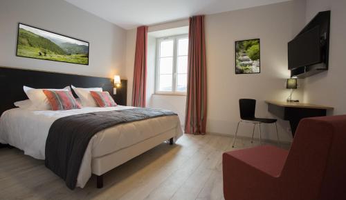 a bedroom with a bed and a desk and a television at Domaine Agerria in Mauléon-Licharre