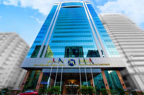 a tall blue building with a sign on it at Grand Mercure Abu Dhabi in Abu Dhabi