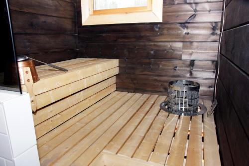 a wooden sauna with a barrel in the middle at Villa Kuukkeli in Salla
