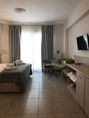 テッサロニキにあるLion Apartment Portのベッドとリビングルームが備わるホテルルームです。