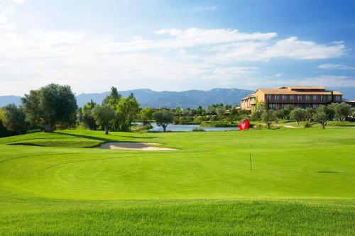 a green golf course with a building in the background at Hotel Peralada Wine Spa & Golf in Peralada