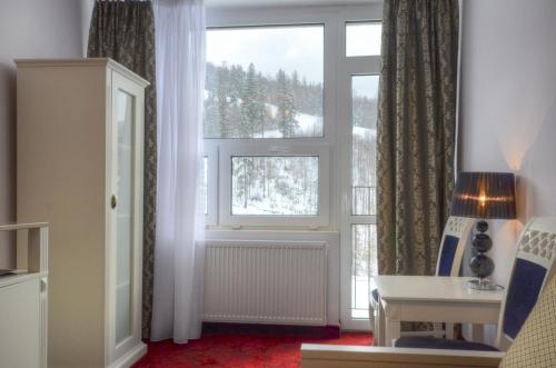 a living room with a window and a table and a desk at GWAREK Centrum Wypoczynkowe in Ustroń