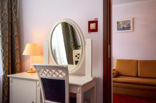 a room with a mirror and a table with a chair at GWAREK Centrum Wypoczynkowe in Ustroń