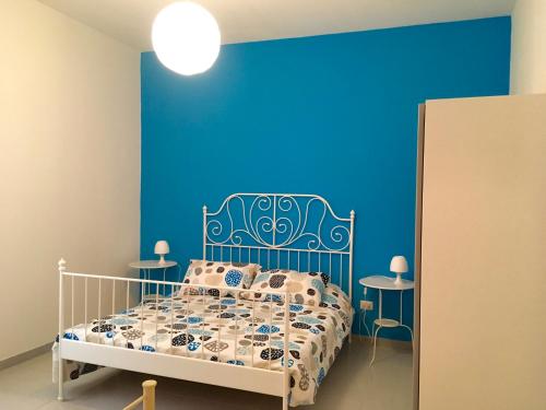 a blue bedroom with a bed and two tables at Apartament Victoria 150mt from beach in Castelsardo
