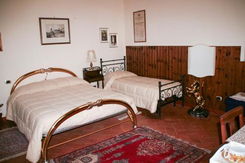 1 dormitorio con 2 camas y alfombra en Antica Cittadella B&B, en Arezzo