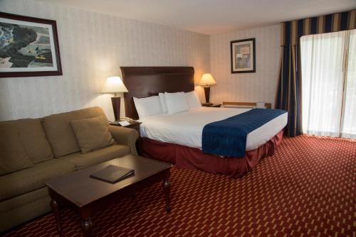 um quarto de hotel com uma cama e um sofá em Hampton Falls Inn em Hampton Falls