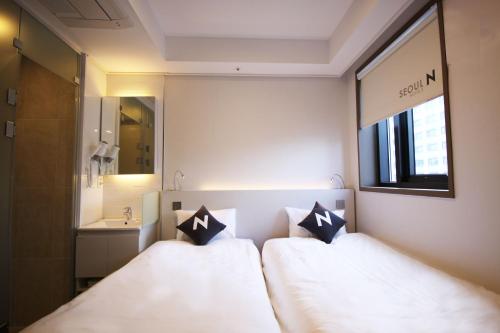 a hotel room with two beds and a sink at Seoul N Guesthouse Dongdaemoon in Seoul