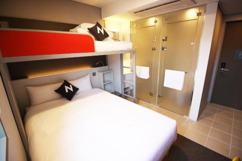 a bedroom with two bunk beds and a bathroom at Seoul N Guesthouse Dongdaemoon in Seoul