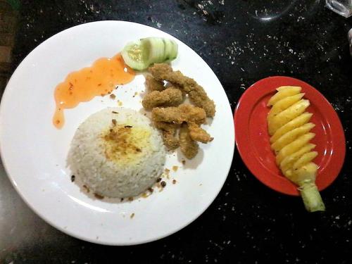 a plate of food with rice and vegetables on a table at Fj Manila Hotel in Daraga