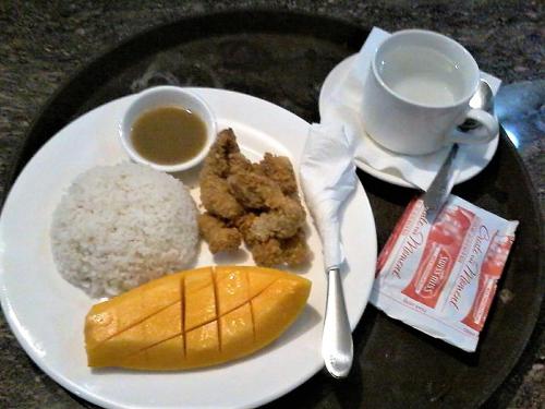 a plate of food with rice and a cup of coffee at Fj Manila Hotel in Daraga