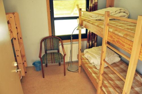 a room with two bunk beds and a chair at Vimmerby Vandrarhem in Vimmerby