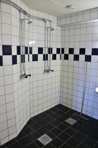 a bathroom with a black and white tiled shower at Vimmerby Vandrarhem in Vimmerby