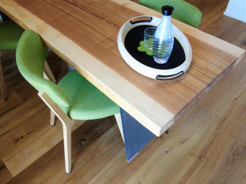 a table with a green chair and a bottle on it at Brauhaus 3 - Adults only in Königsberg in Bayern