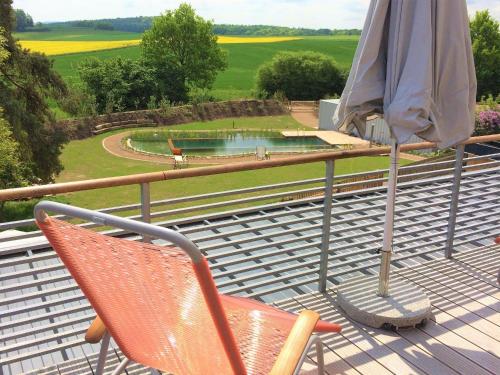 a patio with two chairs and an umbrella and a pool at Brauhaus 3 - Adults only in Königsberg in Bayern