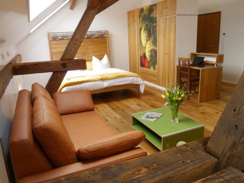 a bedroom with a bed and a couch and a table at Brauhaus 3 - Adults only in Königsberg in Bayern