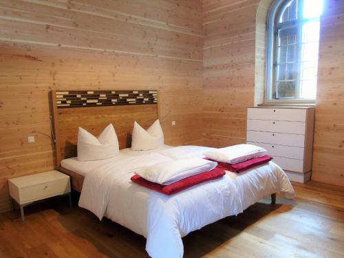 a bedroom with a large white bed with wooden walls at Brauhaus 3 - Adults only in Königsberg in Bayern