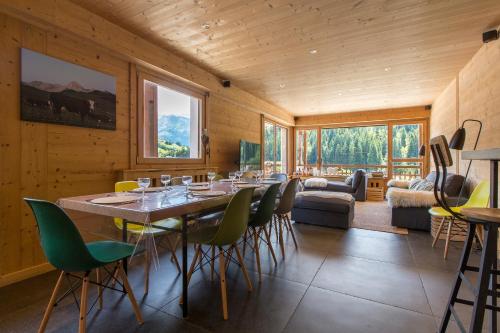 une salle à manger avec une longue table et des chaises dans l'établissement Appartement Le Danay 10 personnes, au Grand-Bornand