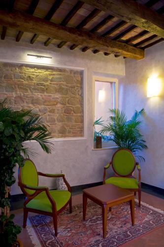 two chairs and a table in a room with a brick wall at Relais Villa Fornari in Camerino