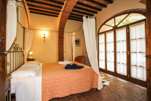 a bedroom with a bed in a room with windows at Appartamenti Castelletto in Sinalunga