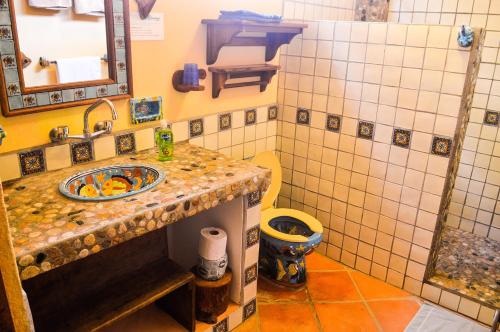 a bathroom with a sink and a toilet at Hotel Casamar Suites in Puerto Escondido
