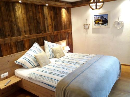 a bedroom with a large bed with a wooden wall at Apart- Chalet GletscherGlück in Telfes im Stubai