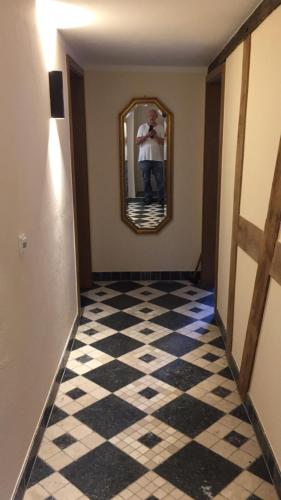 a man taking a picture of a hallway with a mirror at McMüller's Kemenate Fulda in Fulda