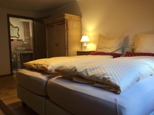 a bedroom with a large bed with white sheets and red pillows at McMüller's Kemenate Fulda in Fulda